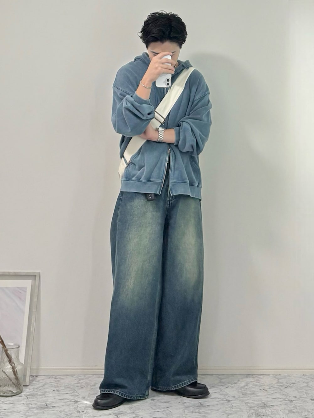 ブラック系のローファー、ブルー系のデニムパンツ、ベージュ系のショルダーバッグを着用したメンズの秋コーディネートの2枚目の写真