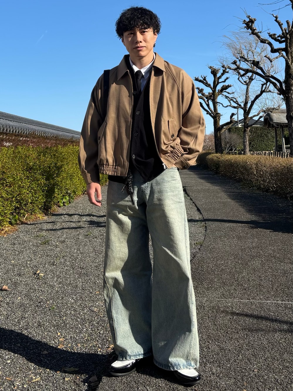 ブラック系のローファー、ブルー系のデニムパンツ、ブラック系のショルダーバッグを着用したメンズの春コーディネートの3枚目の写真