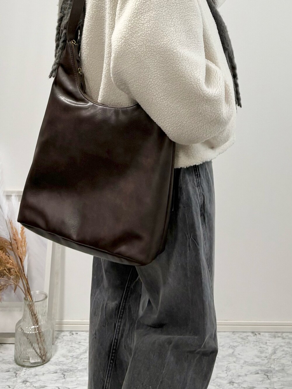 ブラック系のローファー、ブラック系のブルゾン、グレー系のデニムパンツを着用したメンズの冬コーディネートの5枚目の写真