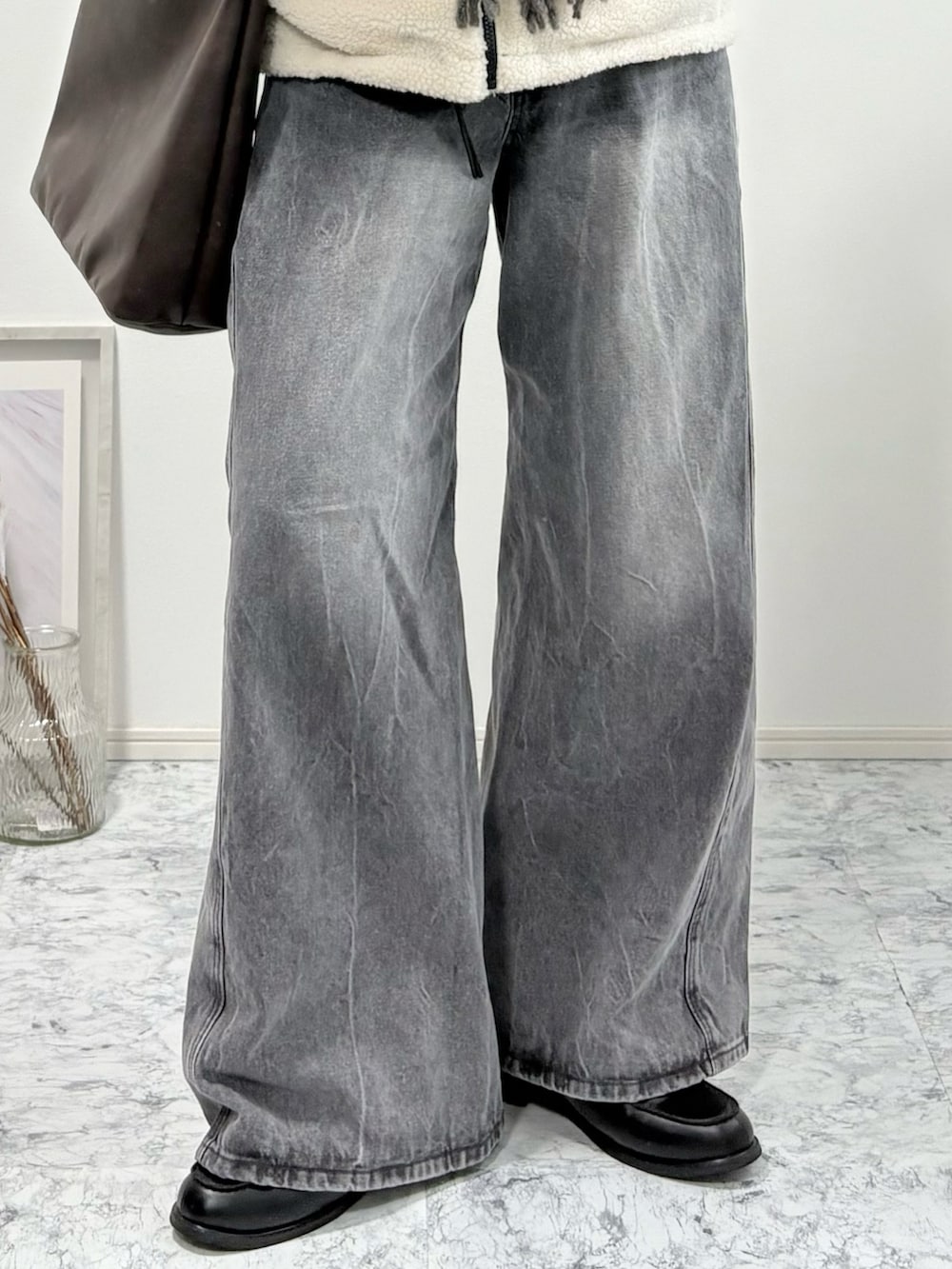 ブラック系のローファー、ブラック系のブルゾン、グレー系のデニムパンツを着用したメンズの冬コーディネートの4枚目の写真