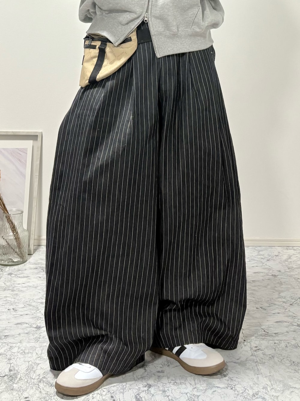 その他のスラックス、グレー系のパーカー、その他のショルダーバッグを着用したメンズの冬コーディネートの5枚目の写真