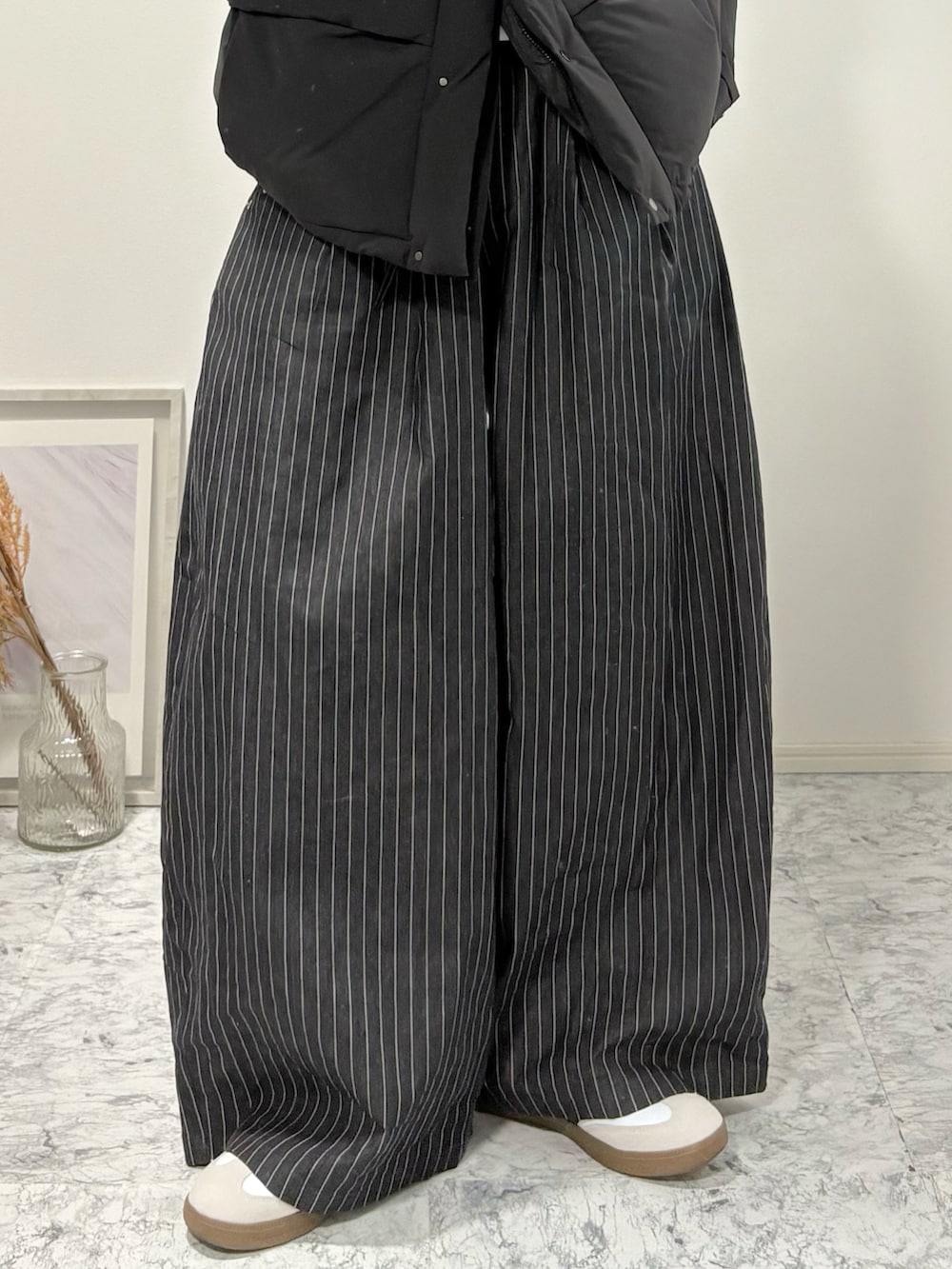 ブラック系のダウンジャケット/コート、その他のスラックス、ホワイト系のスニーカーを着用したメンズの冬コーディネートの4枚目の写真