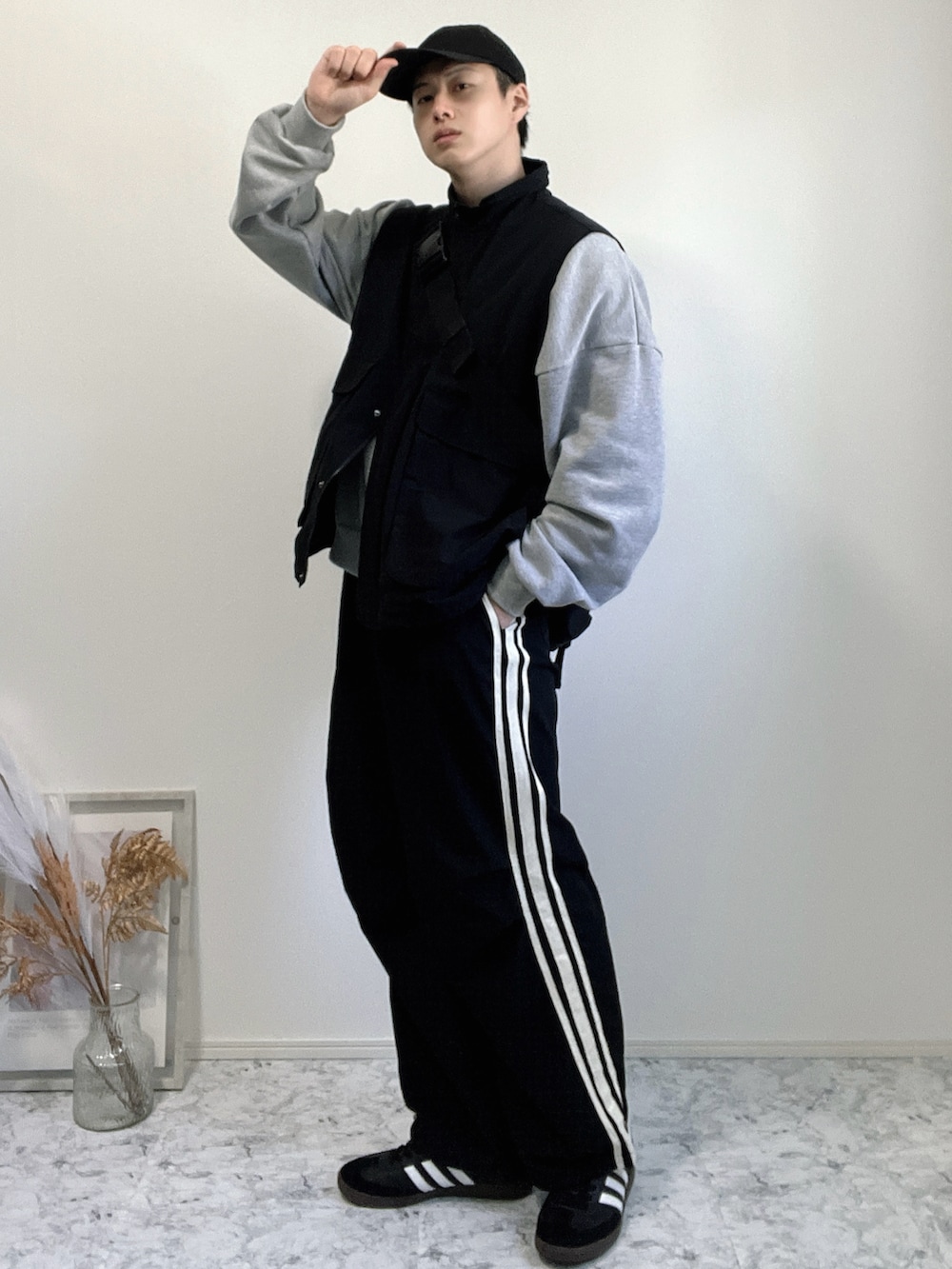 ブラック系のベスト、グレー系のスウェット、ブラック系のパンツを着用したメンズの冬コーディネートの2枚目の写真
