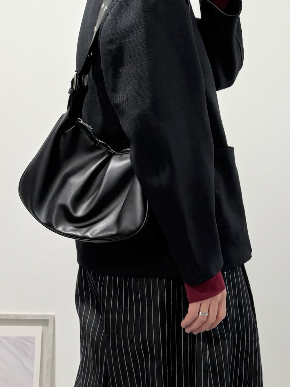 その他のスラックス、ブラック系のローファー、ブラック系のハンドバッグを着用したメンズの冬コーディネートの4枚目の写真