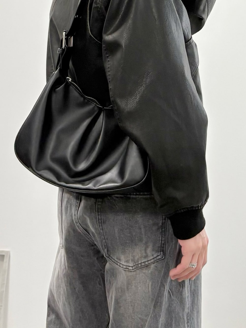 ブラック系のローファー、ブラック系のブルゾン、グレー系のデニムパンツを着用したメンズの冬コーディネートの5枚目の写真