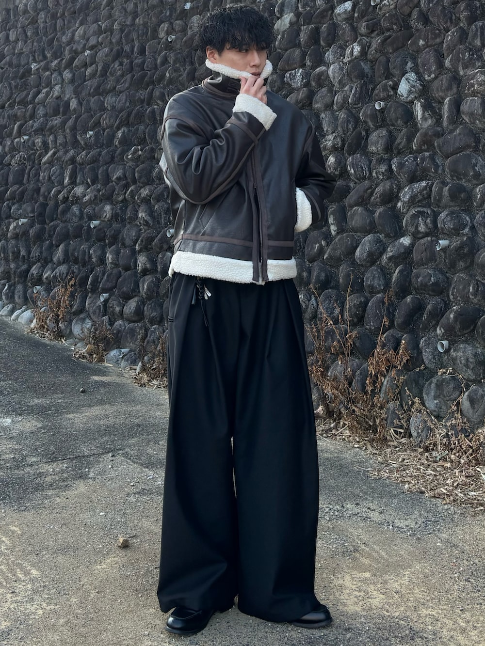 ブラウン系のブルゾン、ブラック系のローファー、ブラウン系のポロシャツを着用したメンズの冬コーディネートの4枚目の写真