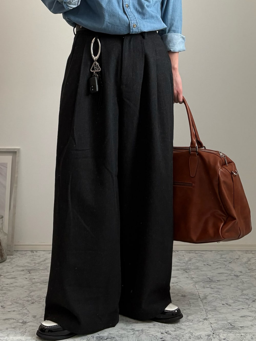 ブラック系のローファー、イエロー系のボストンバッグ、グレー系のスラックスを着用したメンズの春コーディネートの3枚目の写真