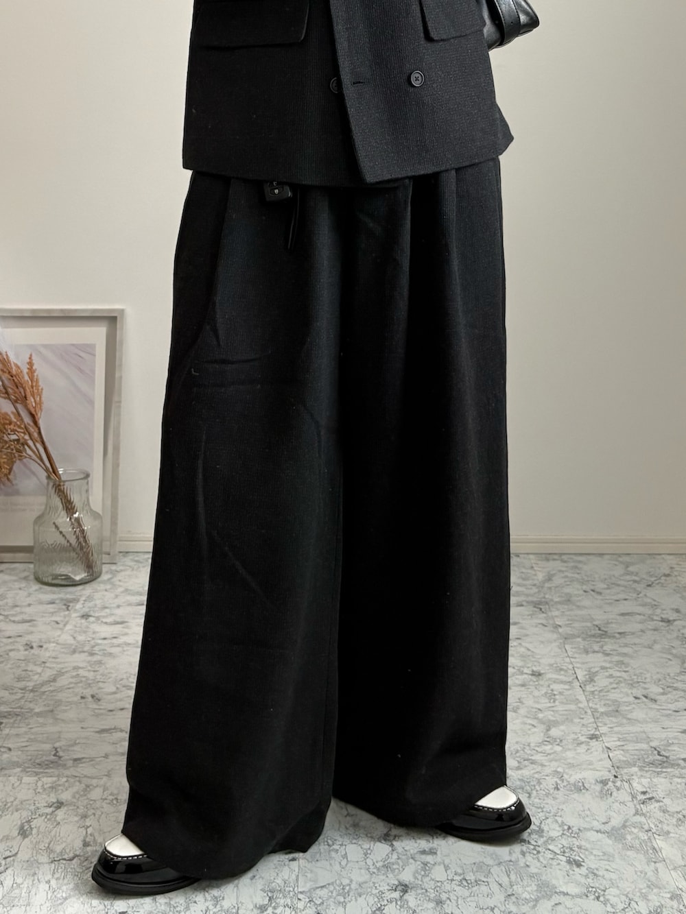 ブラック系のローファー、グレー系のテーラードジャケット、ブラック系のスウェットパンツを着用したメンズの春コーディネートの4枚目の写真