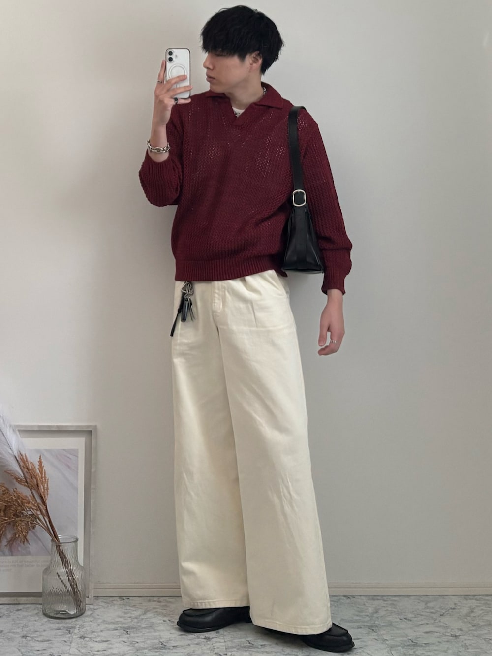 ブラック系のローファー、レッド系のニット/セーター、ホワイト系のデニムパンツを着用したメンズの春コーディネートの2枚目の写真