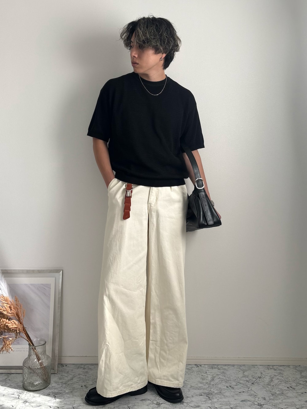 ホワイト系のデニムパンツ、ブラック系のローファー、ブラック系のTシャツ/カットソーを着用したメンズの夏コーディネートの2枚目の写真