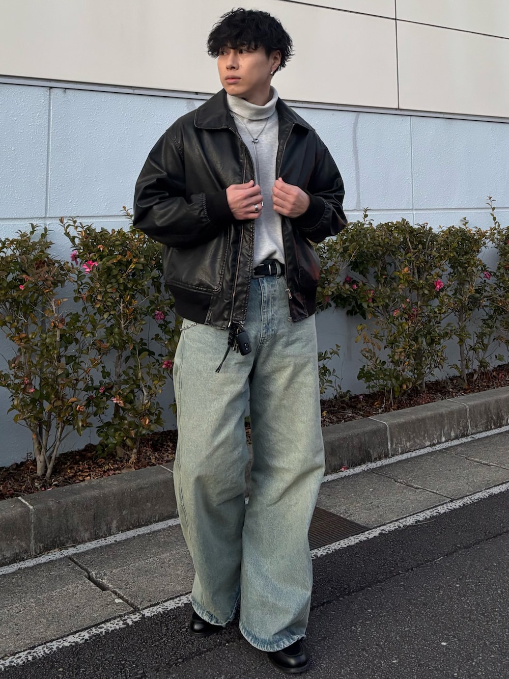 ブラック系のローファー、グレー系のニット/セーター、ブルー系のデニムパンツを着用したメンズの冬コーディネートの3枚目の写真