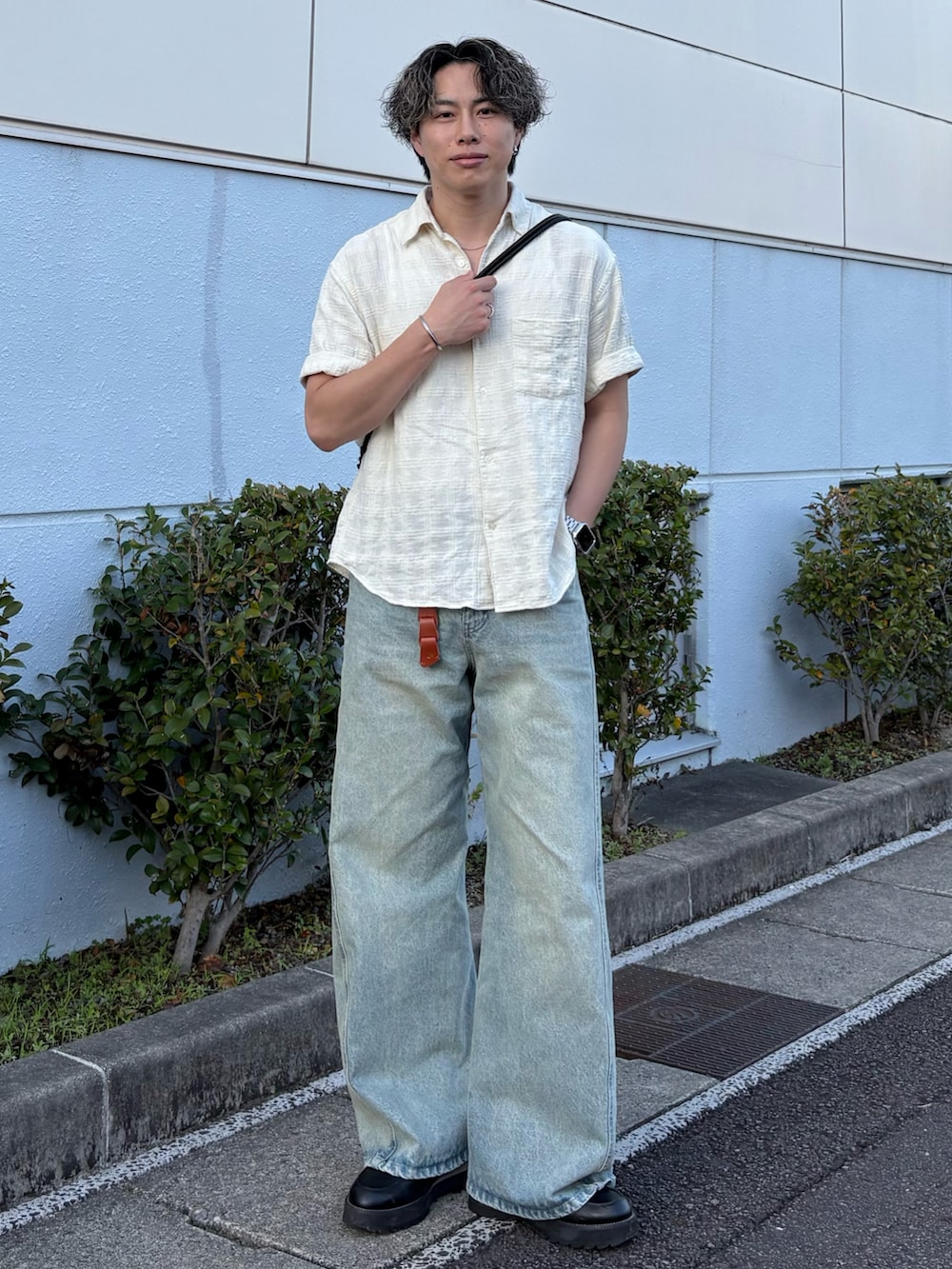 ブルー系のデニムパンツ、ホワイト系のシャツ/ブラウス、ブラック系のショルダーバッグを着用したメンズの夏コーディネートの2枚目の写真