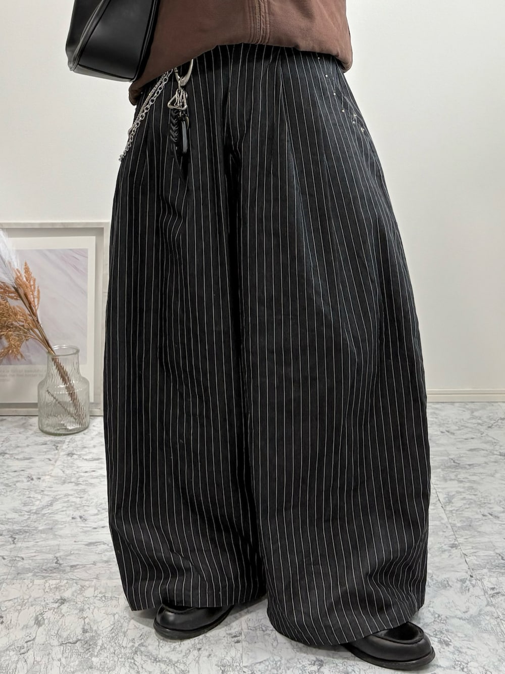 ブラック系のローファー、ブラウン系のブルゾン、その他のスラックスを着用したメンズの冬コーディネートの4枚目の写真