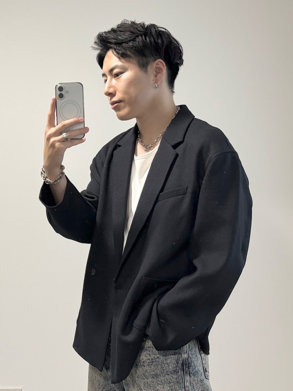 ホワイト系のタンクトップ、ブラック系のドレスシューズ、ブルー系のデニムパンツを着用したメンズの秋コーディネートの3枚目の写真