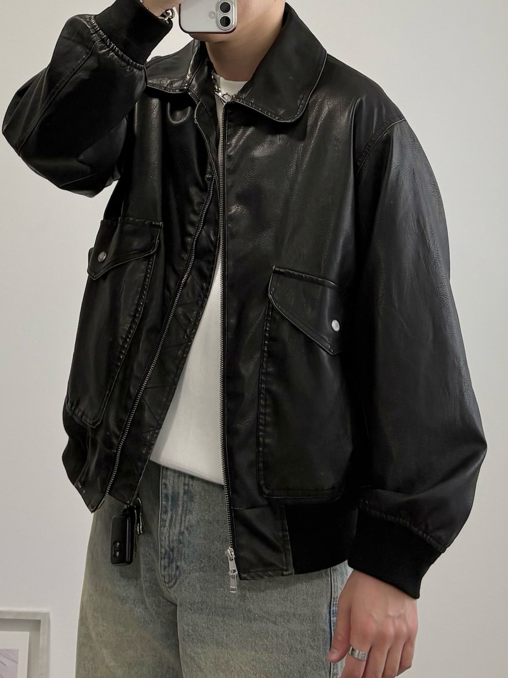 ブラック系のブルゾン、ブルー系のデニムパンツ、ブラック系のドレスシューズを着用したメンズの秋コーディネートの2枚目の写真