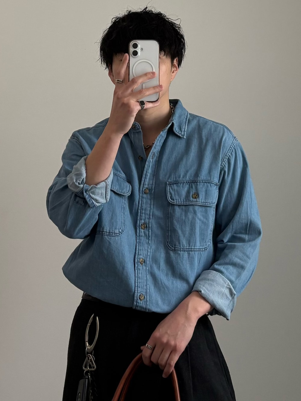 ブラック系のローファー、イエロー系のボストンバッグ、グレー系のスラックスを着用したメンズの春コーディネートの2枚目の写真