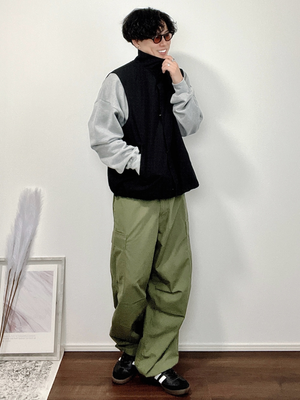 ブラック系のベスト、グレー系のスウェット、グリーン系のカーゴパンツを着用したメンズの秋コーディネートの2枚目の写真