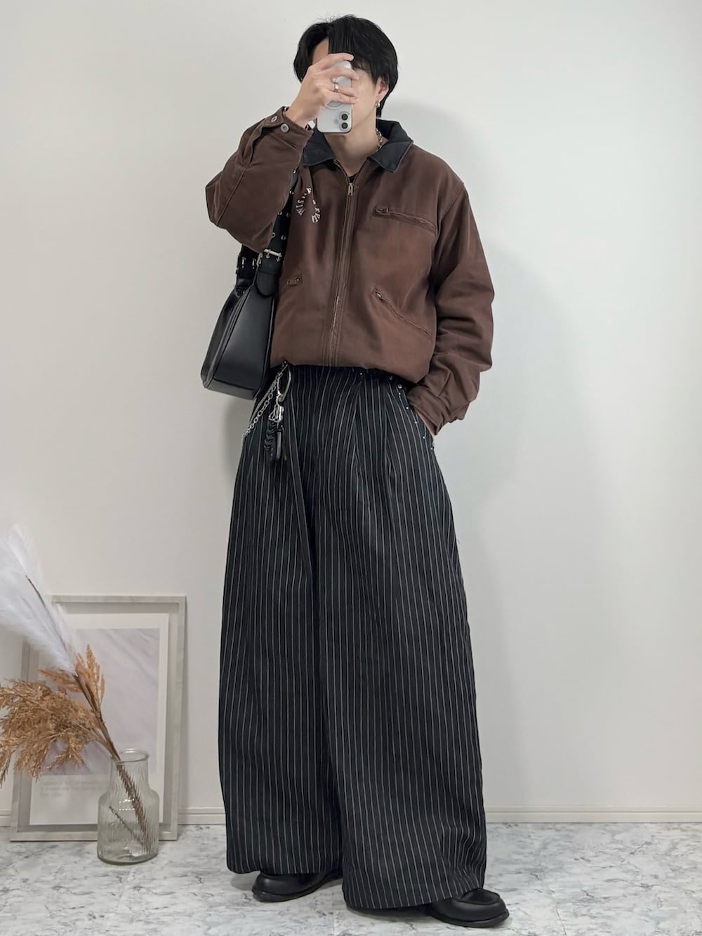 ブラック系のローファー、ブラウン系のブルゾン、その他のスラックスを着用したメンズの冬コーディネートの2枚目の写真