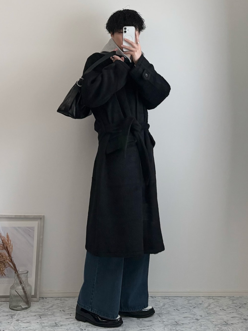 ブラック系のローファー、グレー系のパーカー、ブラック系のステンカラーコートを着用したメンズの冬コーディネートの2枚目の写真