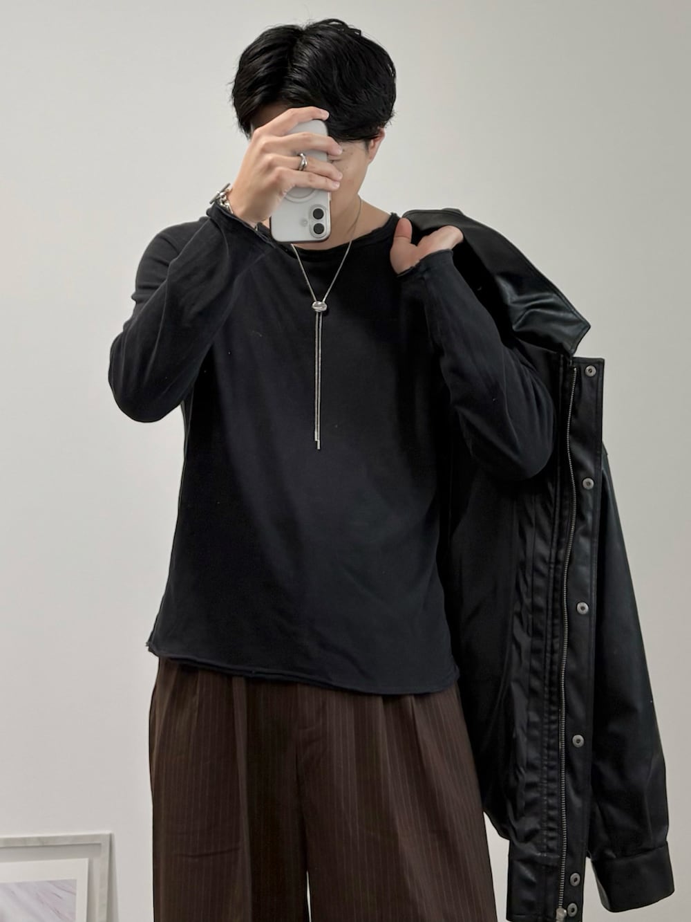 ベージュ系のショルダーバッグ、ブラック系のブルゾン、ブラック系のドレスシューズを着用したメンズの秋コーディネートの3枚目の写真