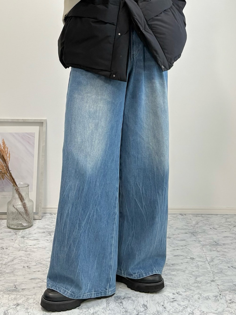 ブラック系のダウンジャケット/コート、ベージュ系のショルダーバッグ、ブルー系のデニムパンツを着用したメンズの冬コーディネートの5枚目の写真