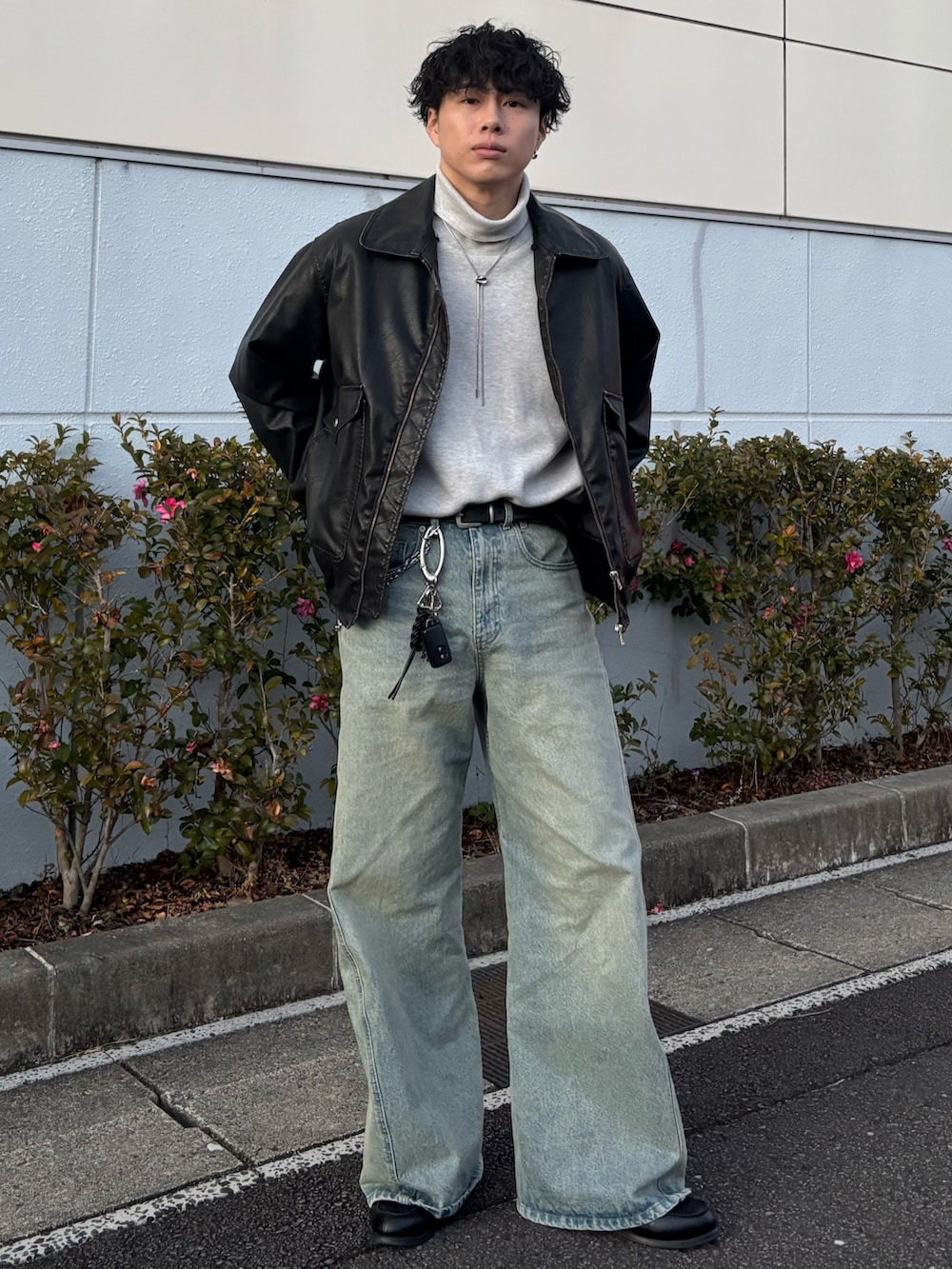 ブラック系のローファー、グレー系のニット/セーター、ブルー系のデニムパンツを着用したメンズの冬コーディネートの2枚目の写真