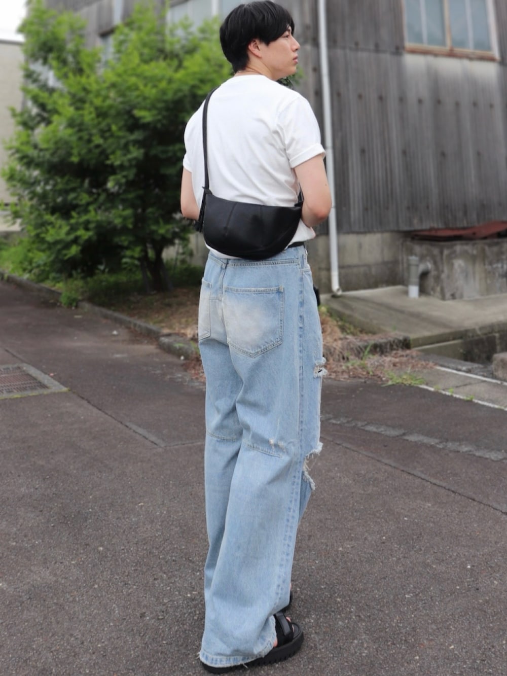 ブラック系のサンダル、ブルー系のデニムパンツ、ブラック系のショルダーバッグを着用したメンズの秋コーディネートの2枚目の写真