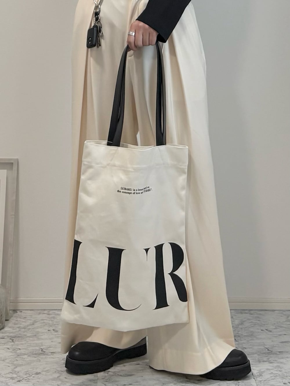 ブラック系のTシャツ/カットソー、ホワイト系のスラックス、ブラック系のドレスシューズを着用したメンズの秋コーディネートの2枚目の写真