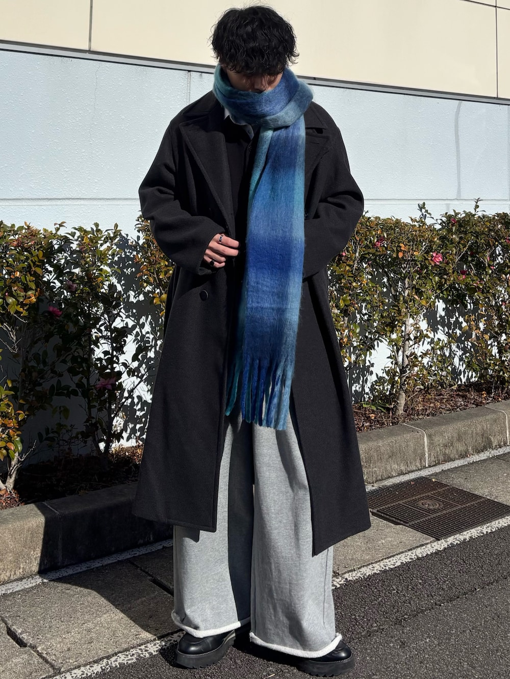 グリーン系のその他アウター、グレー系のスウェットパンツ、ブラック系のドレスシューズを着用したメンズの冬コーディネートの2枚目の写真