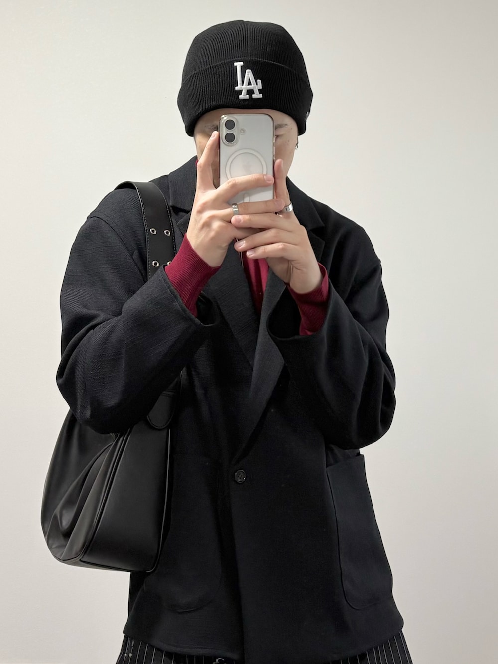 その他のスラックス、ブラック系のローファー、ブラック系のハンドバッグを着用したメンズの冬コーディネートの2枚目の写真