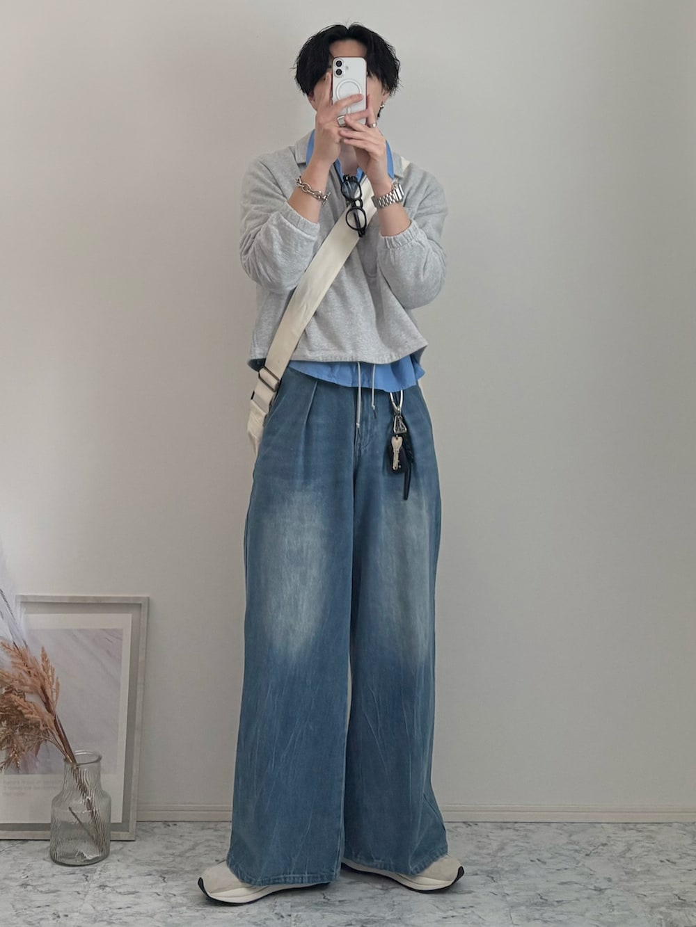 ベージュ系のショルダーバッグ、ブルー系のデニムパンツ、ベージュ系のスニーカーを着用したメンズの春コーディネートの2枚目の写真