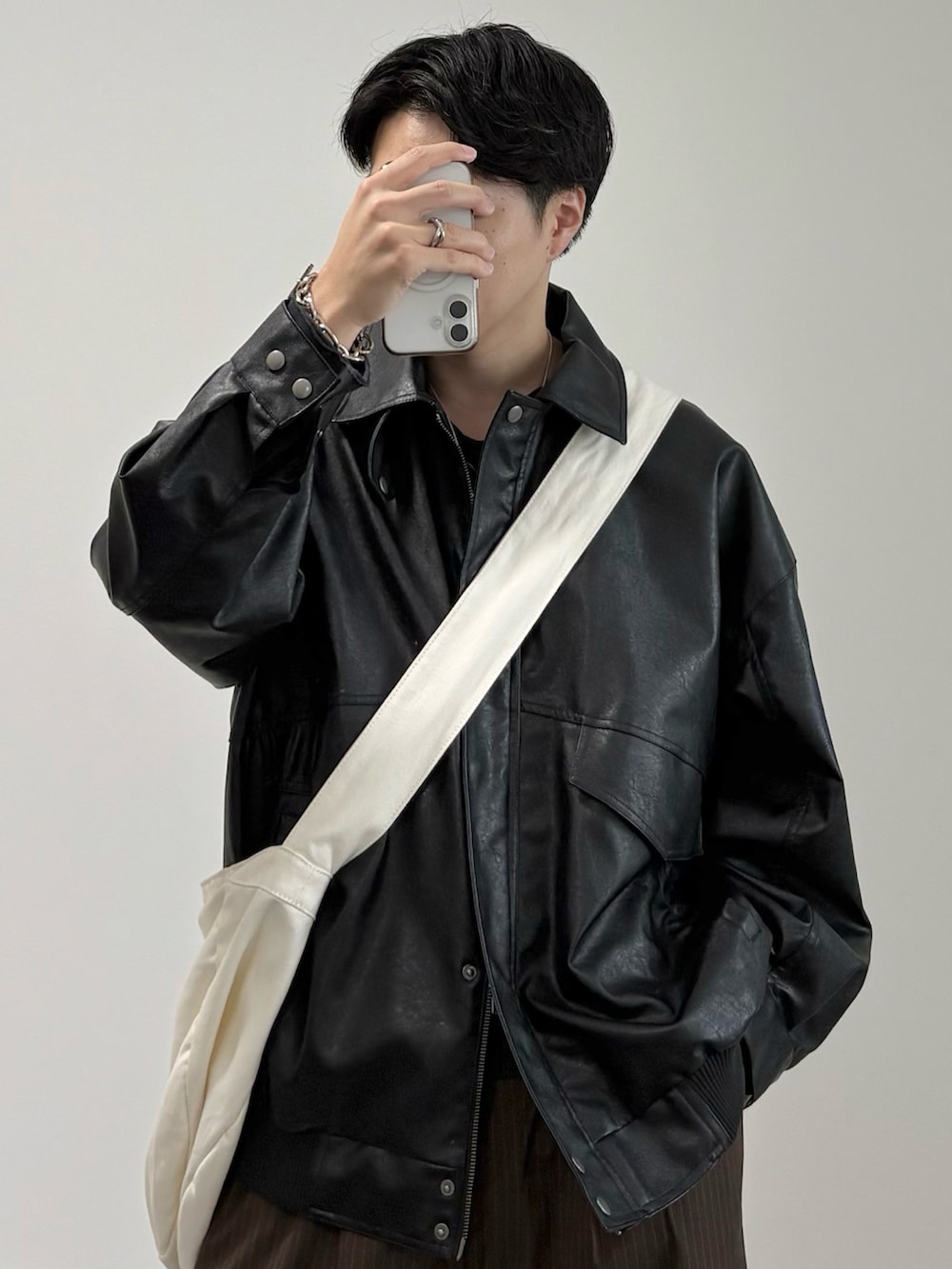 ベージュ系のショルダーバッグ、ブラック系のブルゾン、ブラック系のドレスシューズを着用したメンズの秋コーディネートの2枚目の写真