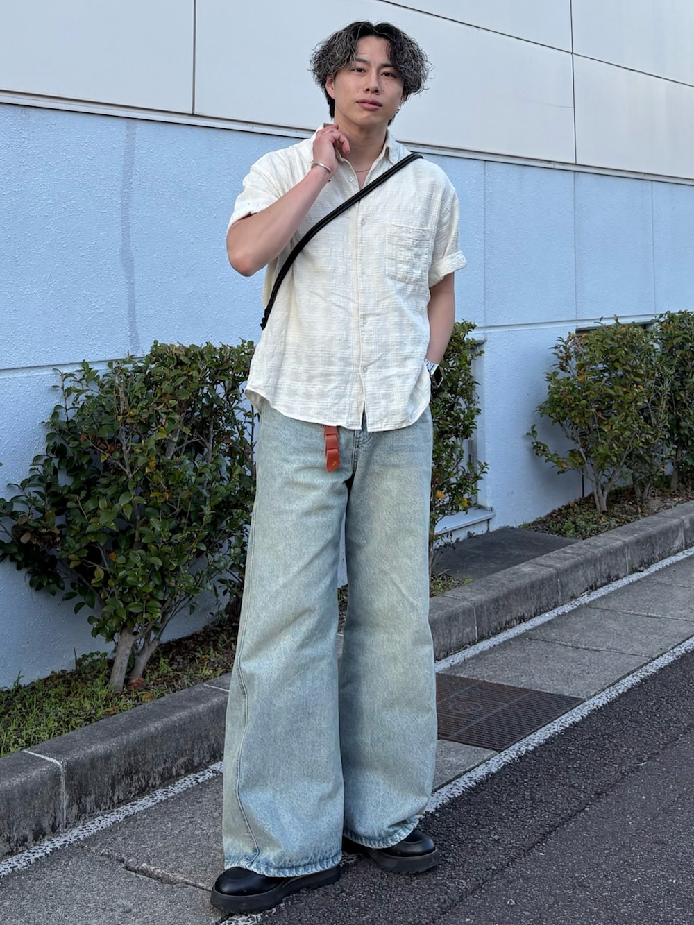 ブルー系のデニムパンツ、ホワイト系のシャツ/ブラウス、ブラック系のショルダーバッグを着用したメンズの夏コーディネートの3枚目の写真