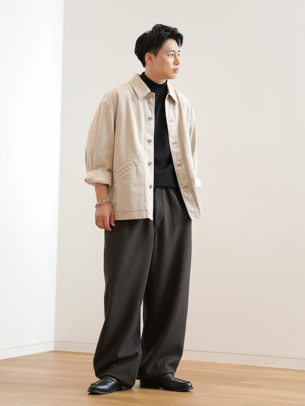 ブラック系のローファー、ブラック系のニット/セーター、ベージュ系のデニムジャケットを着用したメンズの秋コーディネートの2枚目の写真