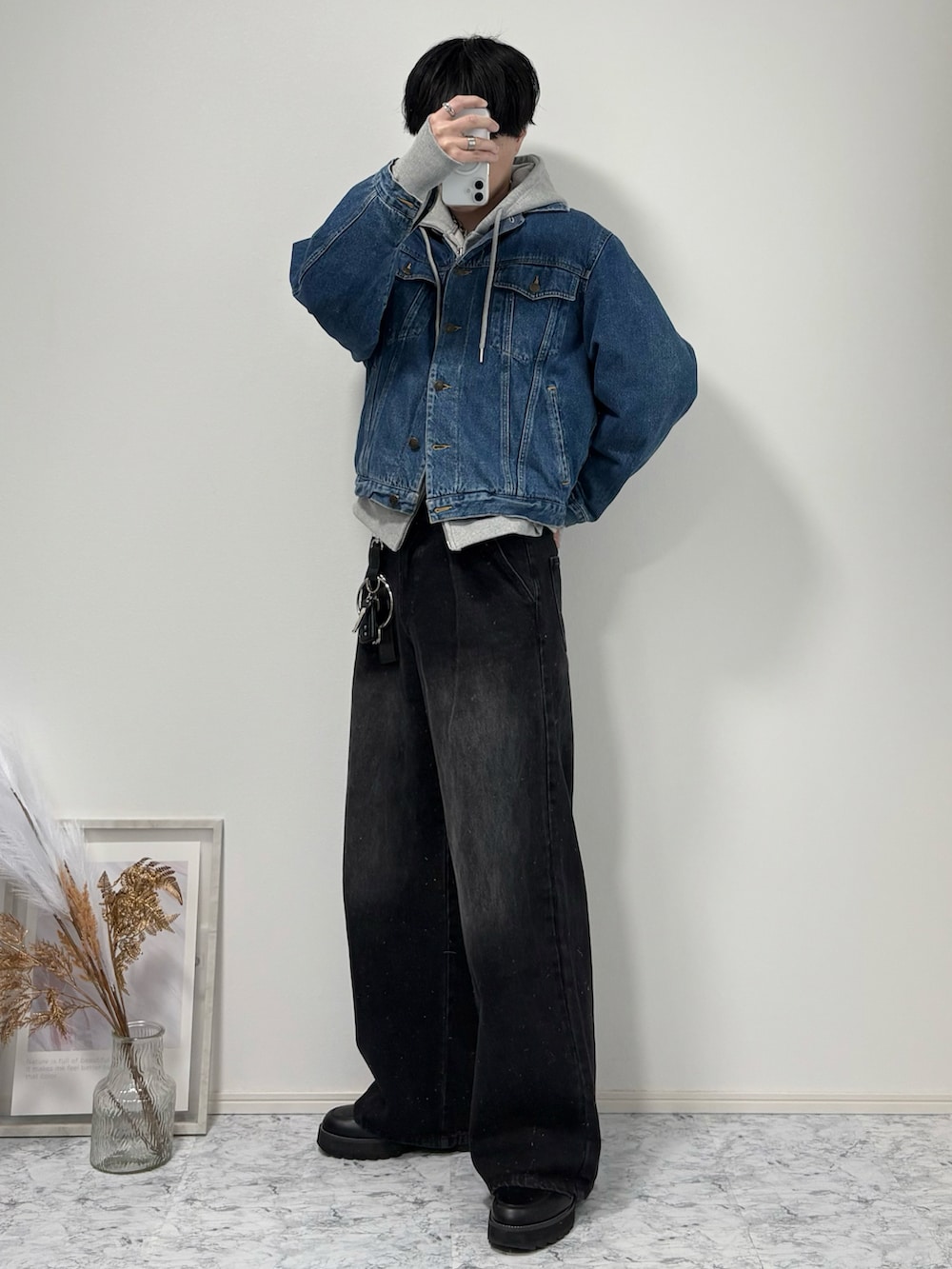 ブルー系のデニムジャケット、グレー系のパーカー、ブラック系のデニムパンツを着用したメンズの春コーディネートの2枚目の写真