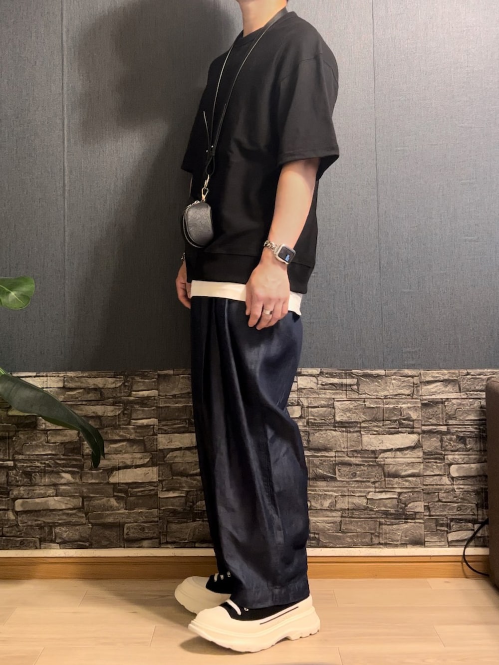 ブラック系のトップス、ブルー系のデニムパンツ、ブラック系のシューズを着用したメンズの夏コーディネートの2枚目の写真