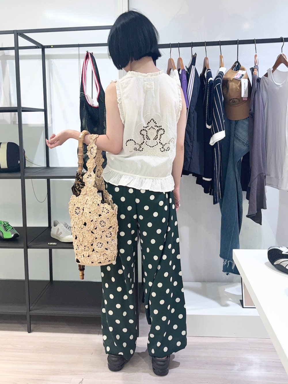 ベージュ系のショルダーバッグ、ホワイト系のベスト、グリーン系のその他パンツを着用したレディースの夏コーディネートの4枚目の写真