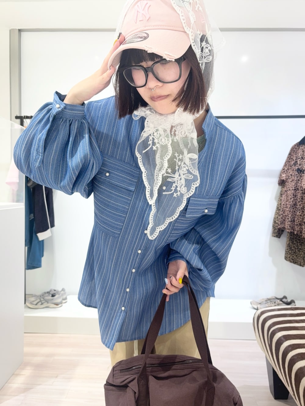 ブルー系のシャツ/ブラウス、ブラック系のブーツ、グリーン系のTシャツ/カットソーを着用したレディースの春コーディネートの5枚目の写真