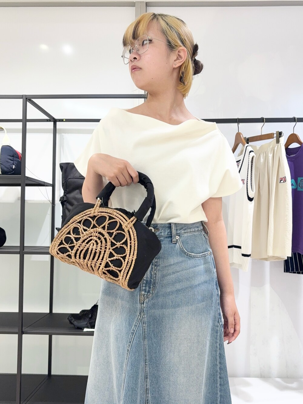 ブラック系のかごバッグ、ブルー系のデニムパンツ、ブラック系のサンダルを着用したレディースの夏コーディネートの4枚目の写真