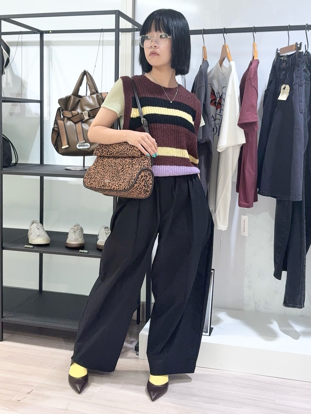 グリーン系のTシャツ/カットソー、ブラウン系のベスト、ブラック系のその他パンツを着用したレディースの秋コーディネートの2枚目の写真