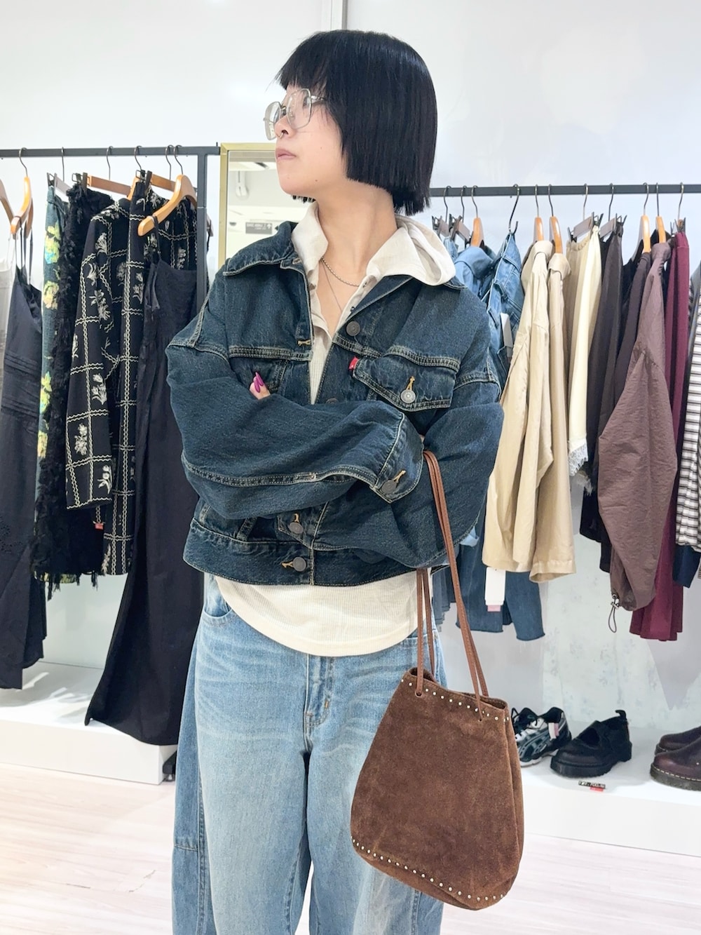 ベージュ系のTシャツ/カットソー、ブルー系のデニムパンツ、ブラウン系のショルダーバッグを着用したレディースの秋コーディネートの5枚目の写真