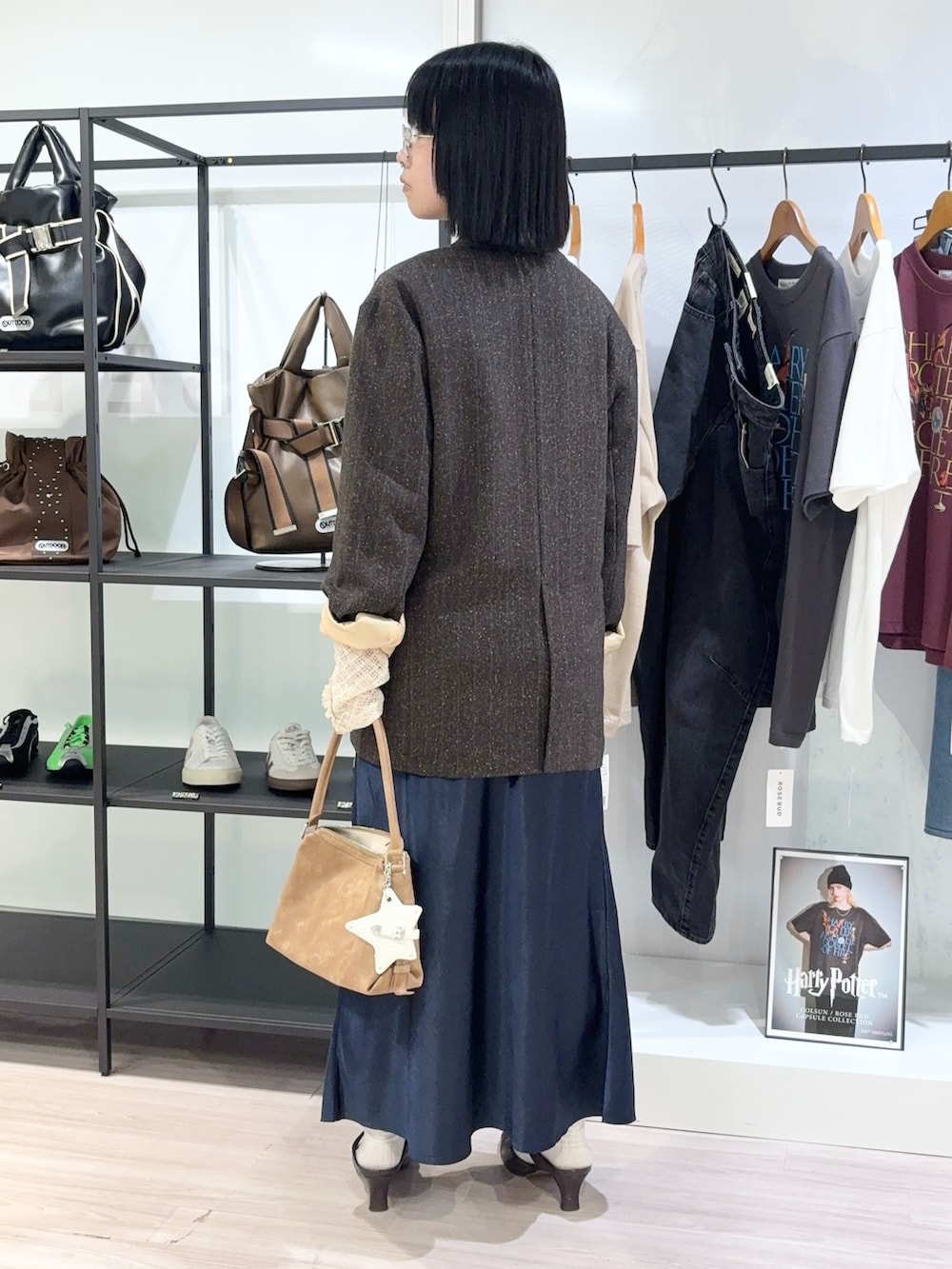 ブラック系のその他シューズ、ブルー系のスカート、ホワイト系のTシャツ/カットソーを着用したレディースの秋コーディネートの3枚目の写真
