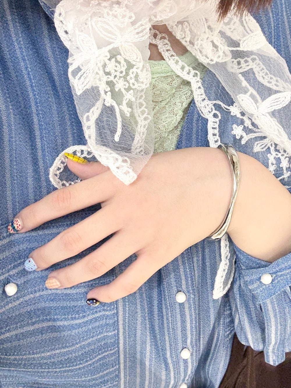 ブルー系のシャツ/ブラウス、ブラック系のブーツ、グリーン系のTシャツ/カットソーを着用したレディースの春コーディネートの7枚目の写真