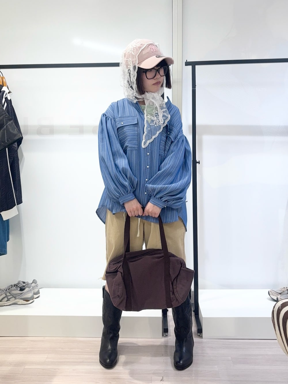 ブルー系のシャツ/ブラウス、ブラック系のブーツ、グリーン系のTシャツ/カットソーを着用したレディースの春コーディネートの2枚目の写真