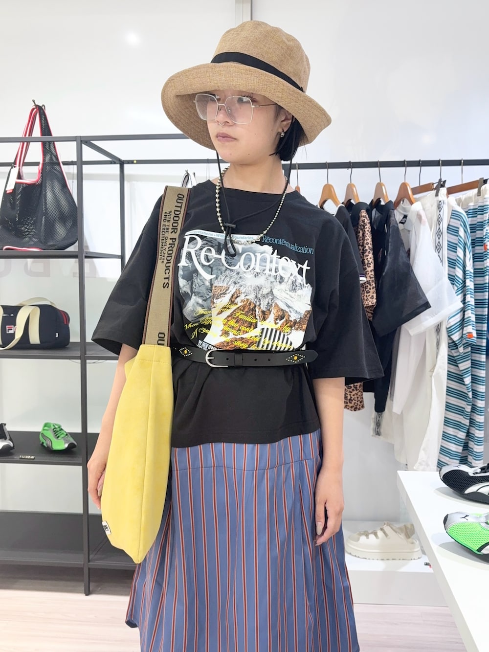 ブルー系のデニムパンツ、ブラック系のスニーカー、イエロー系のトートバッグを着用したレディースの夏コーディネートの5枚目の写真