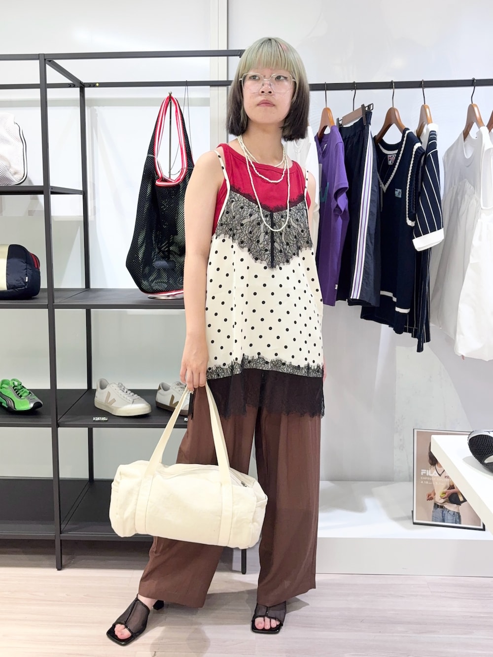 レッド系のタンクトップ、ブラウン系のその他パンツ、ホワイト系のボストンバッグを着用したレディースの夏コーディネートの2枚目の写真