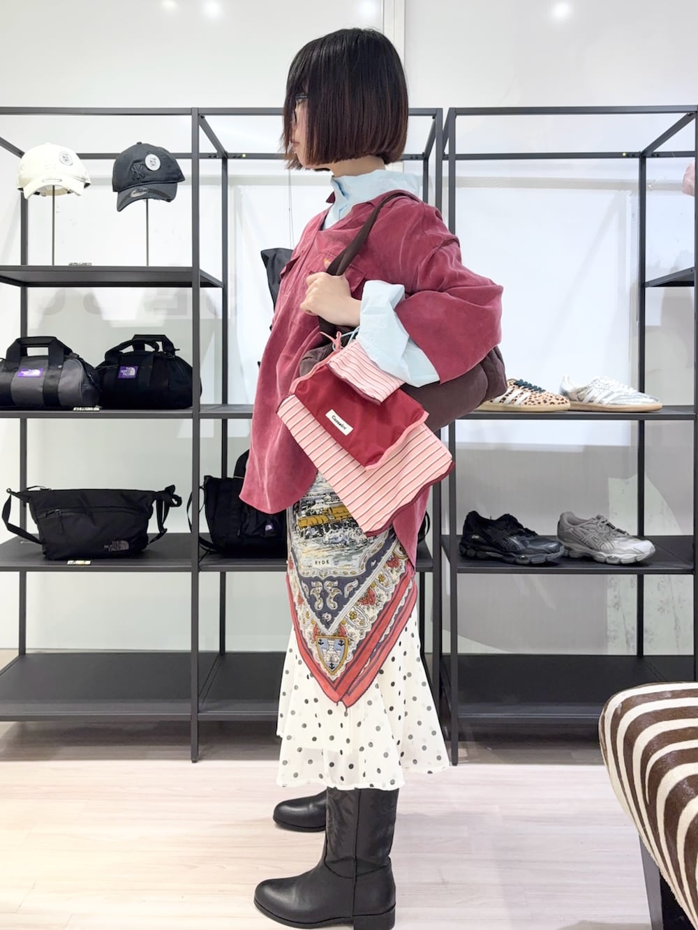 ブルー系のブルゾン、ブラウン系のボストンバッグ、ブラック系のブーツを着用したレディースの春コーディネートの3枚目の写真