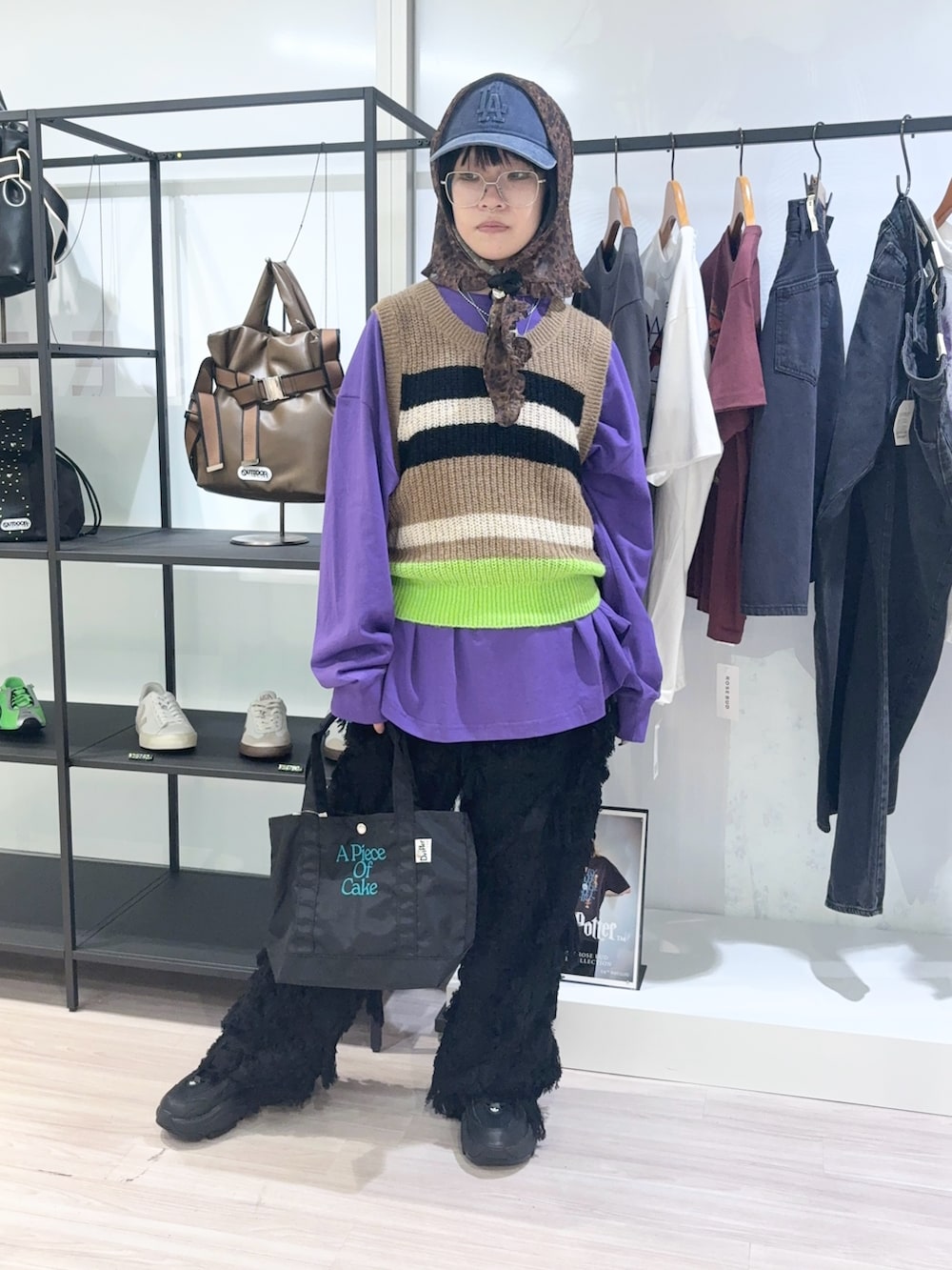 ブラック系のトートバッグ、パープル系のTシャツ/カットソー、ベージュ系のベストを着用したレディースの秋コーディネートの2枚目の写真