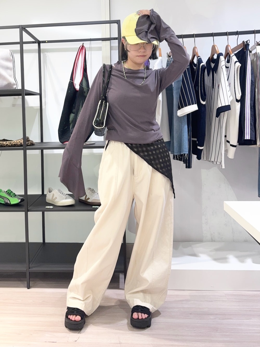 ホワイト系のデニムパンツ、ブラック系のサンダル、グレー系のTシャツ/カットソーを着用したレディースの夏コーディネートの2枚目の写真