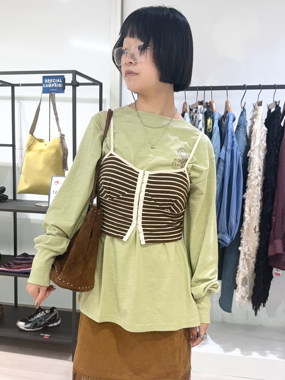 グリーン系のTシャツ/カットソー、ブラウン系のショルダーバッグ、ブラウン系のキャミソールを着用したレディースの秋コーディネートの5枚目の写真